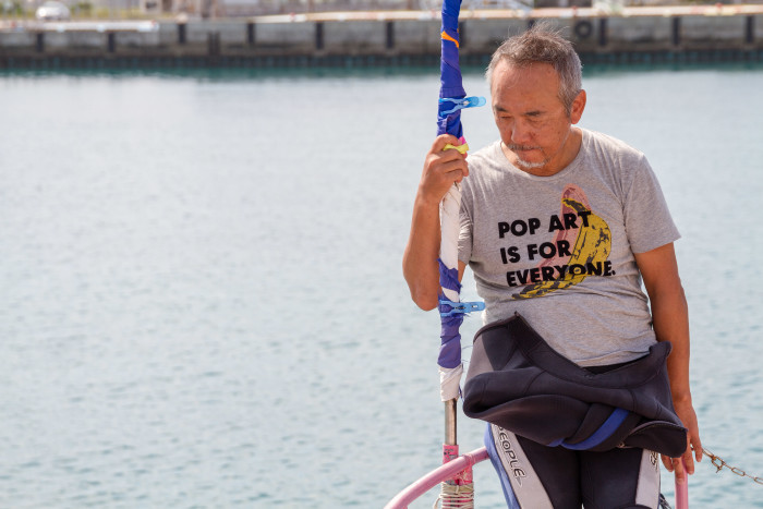 Okinawan man prepares to Dive the beautiful blue waters of Okinawa